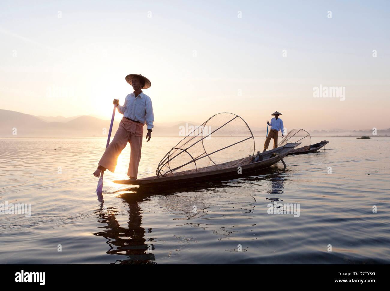Intha leg rowing fishermen at sunset on Inle Lake, Inle Lake, Shan State, Burma Stock Photo