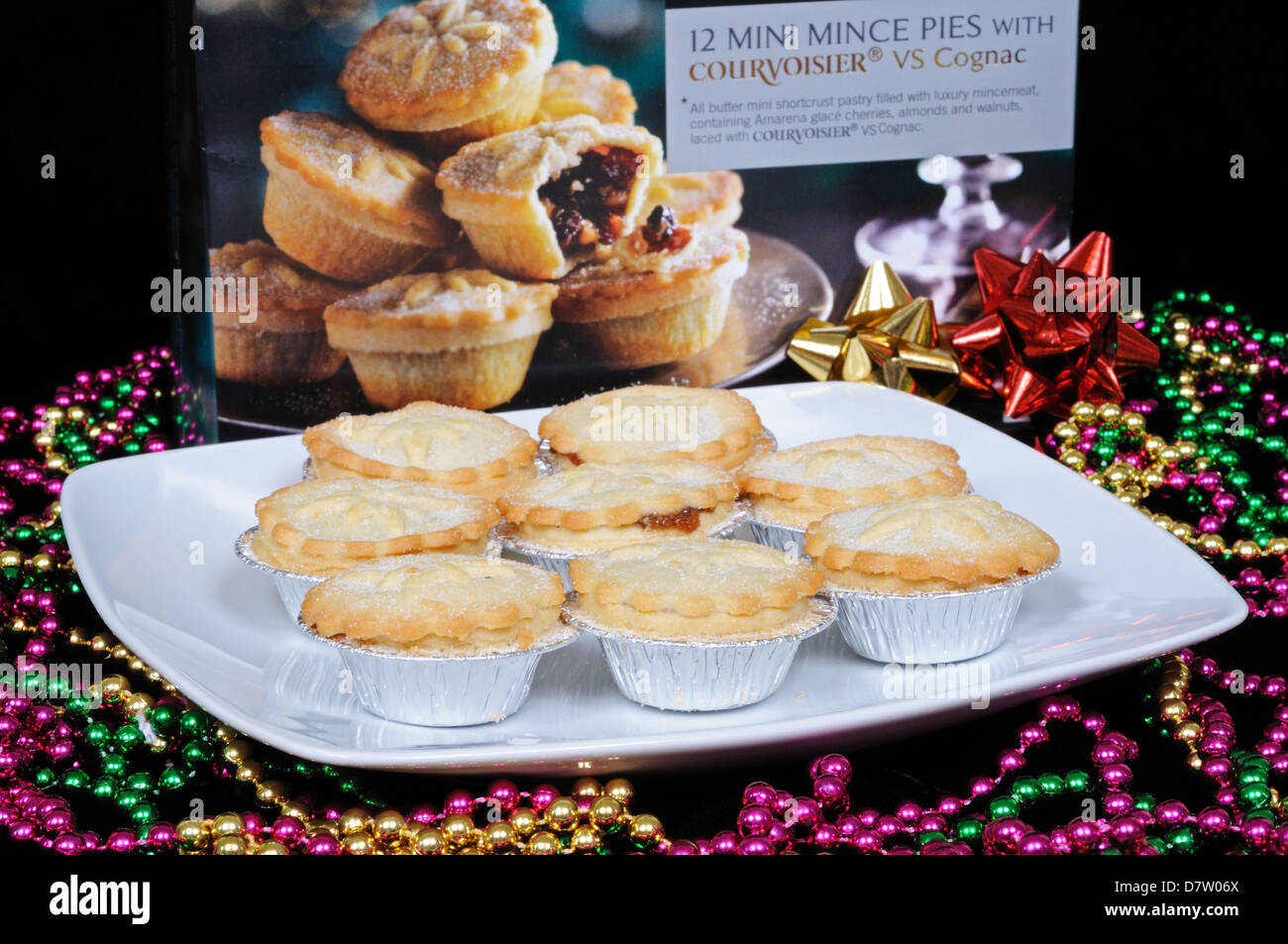 Mince pies on a white plate surrounded by colourful beads, England, UK ...