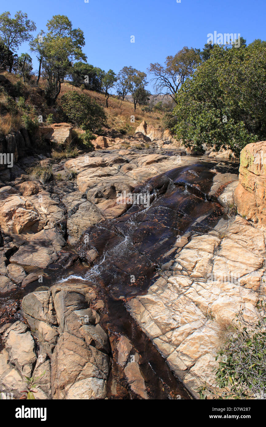 Water trickling over sand-coloured rocks, the Witwatersrand mountains, Magaliesburg, Gauteng, South Africa. Stock Photo