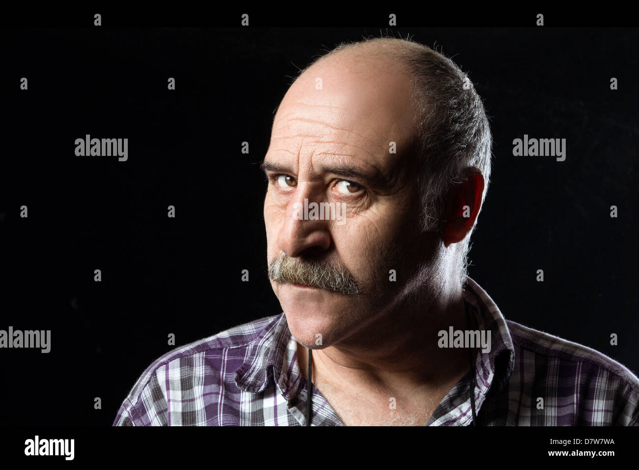 Annoyed bald man with a big mustache expressing anger Stock Photo