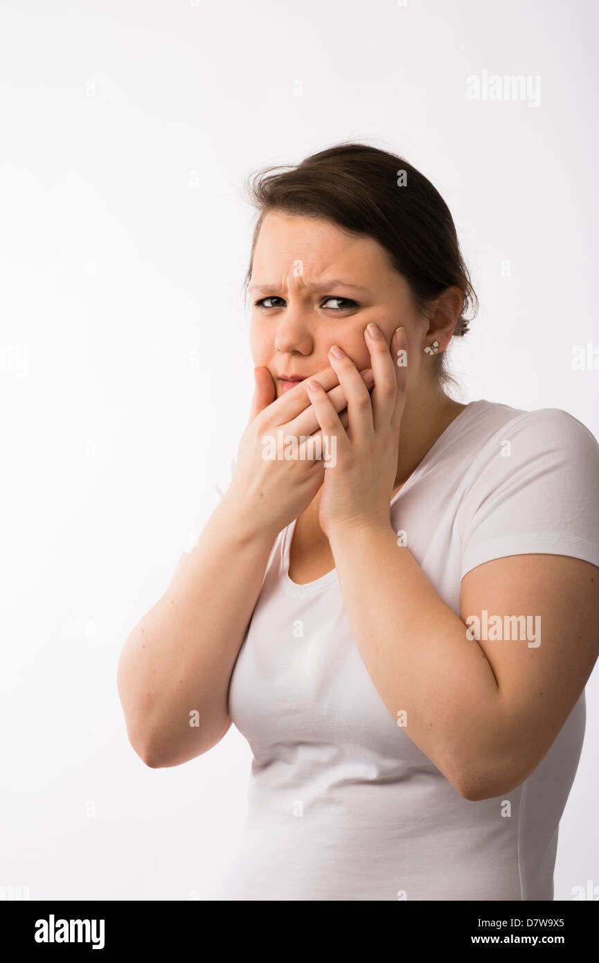 A young brunette teenage Caucasian girl suffering mouth pain toothache sore gums Stock Photo