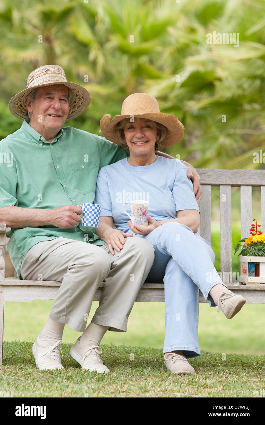 Elderly couple sitting on a bench in the garden Stock Photo - Alamy