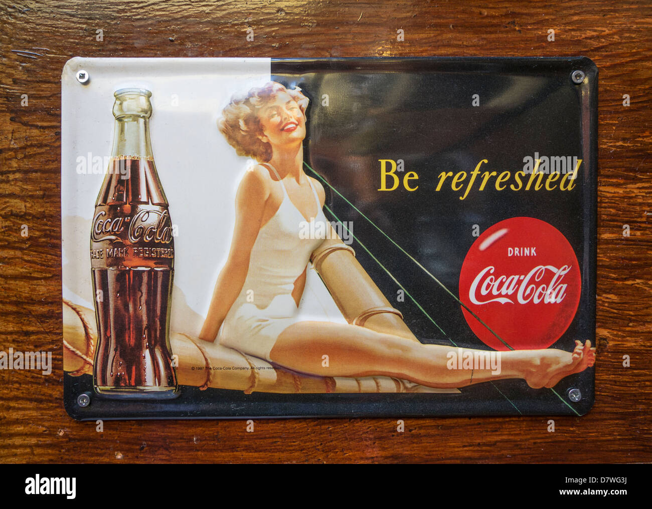 An old metal wall advertisement for Coca-Cola, used as decoration in a modern pub in Dublin Stock Photo