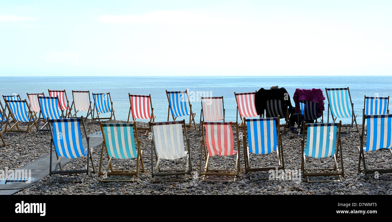 2 people sitting in deck chairs in Beer Devon England uk Stock Photo