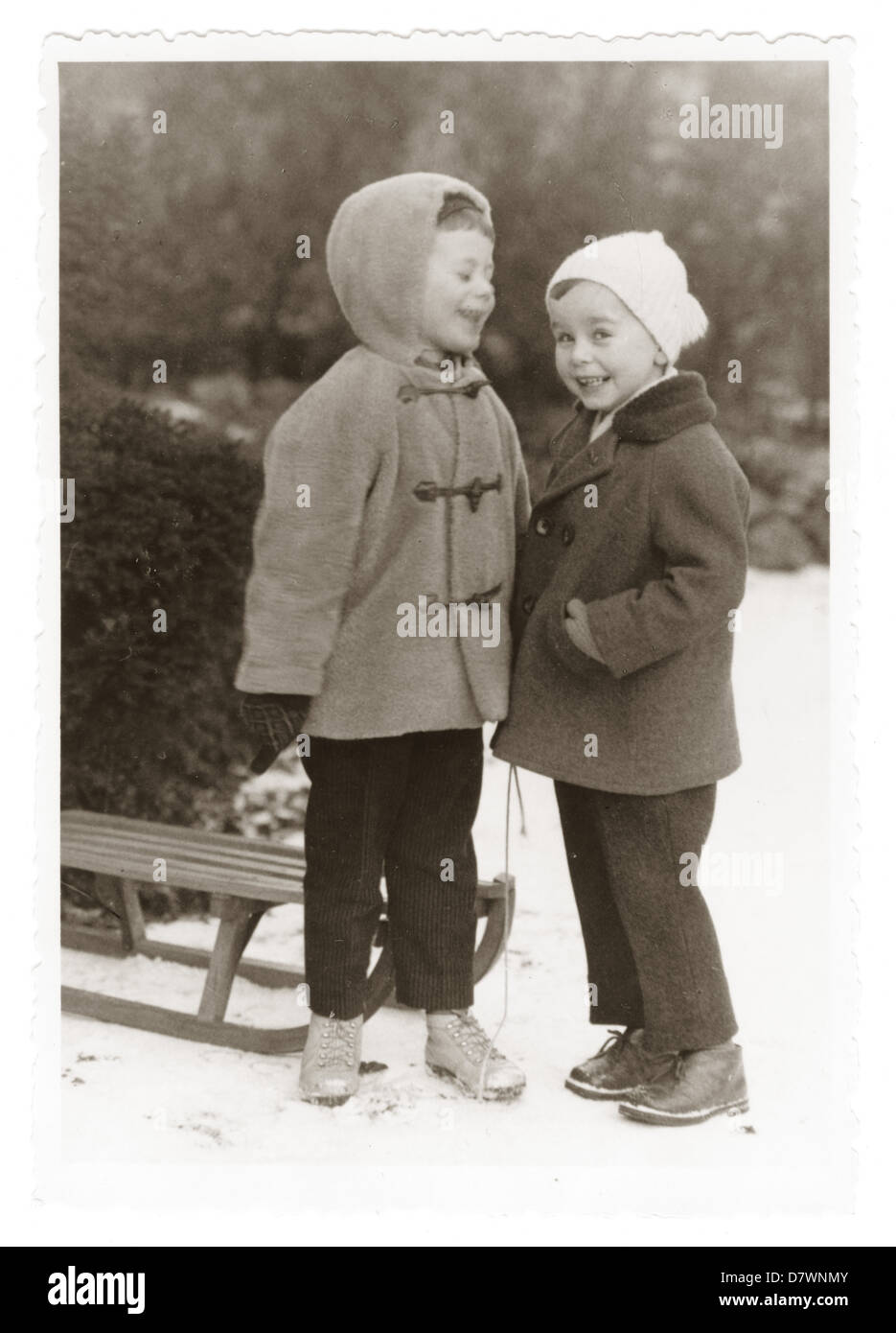 Photograph of two happy young children in the snow with a sledge, Eberswalde, Germany, 1930,s 1940's, pastimes Stock Photo