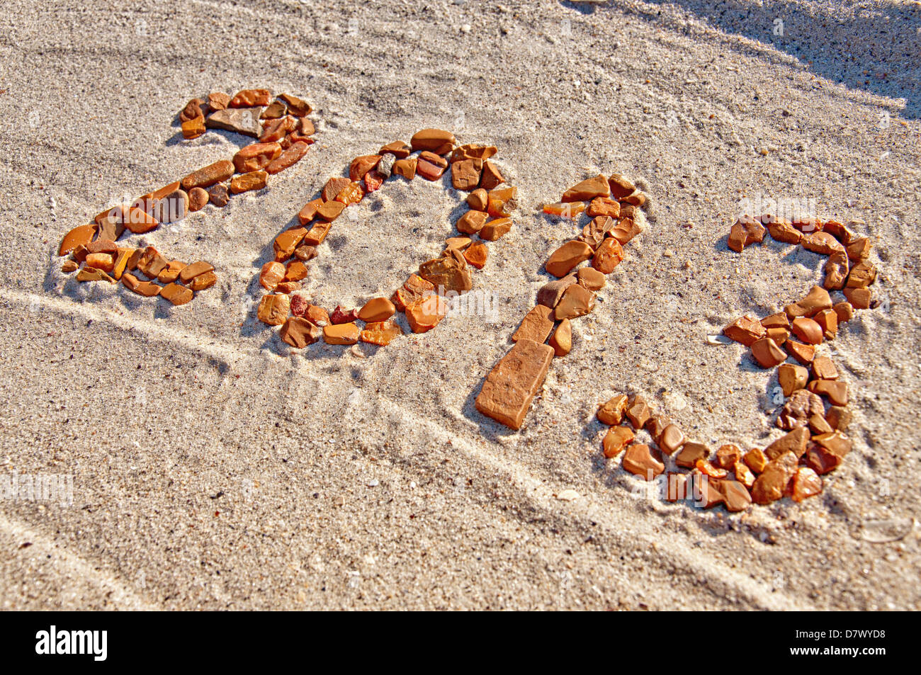 2013 inscription made from pebbles lying on sand surface Stock Photo