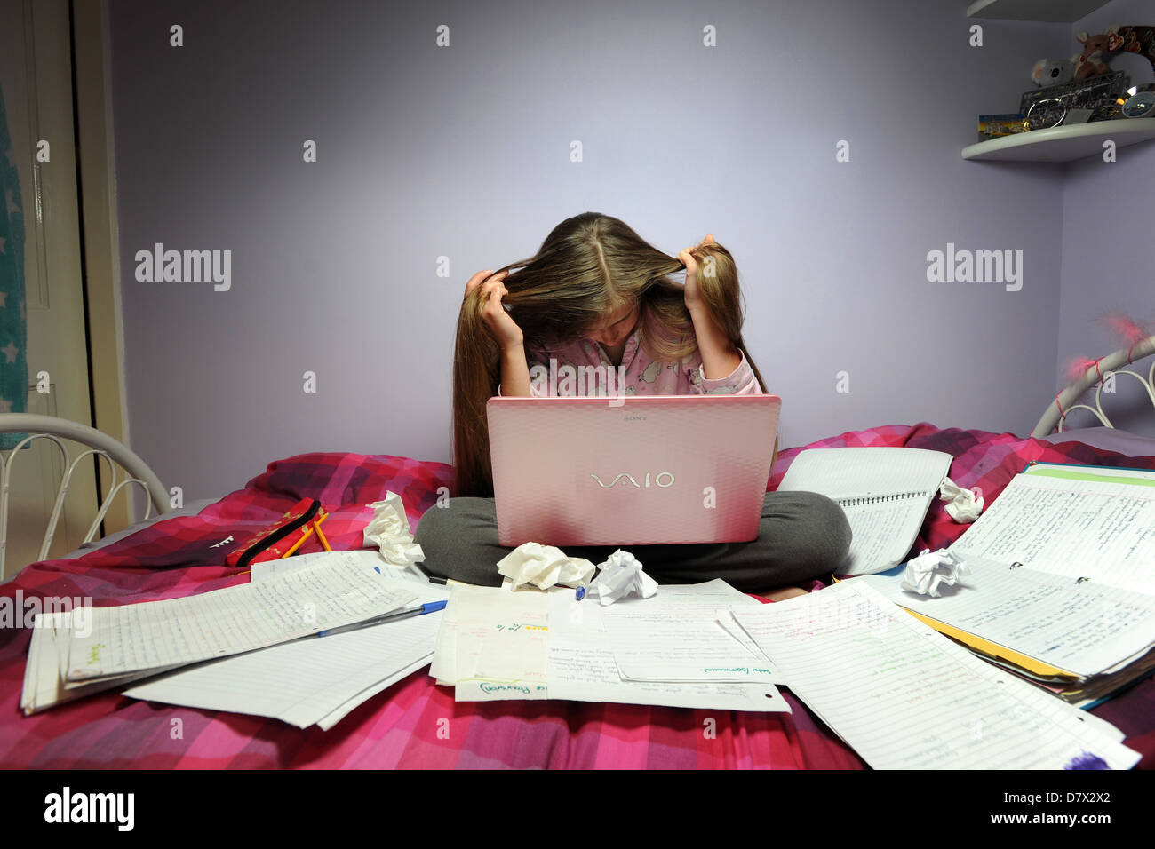 A stressed teenager revising for her exams. Stock Photo