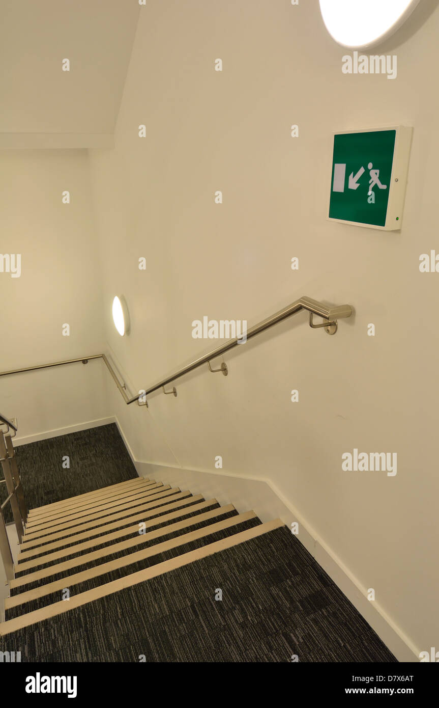Image of a building escape route in a stairwell. Image is focussed on the escape sign Stock Photo