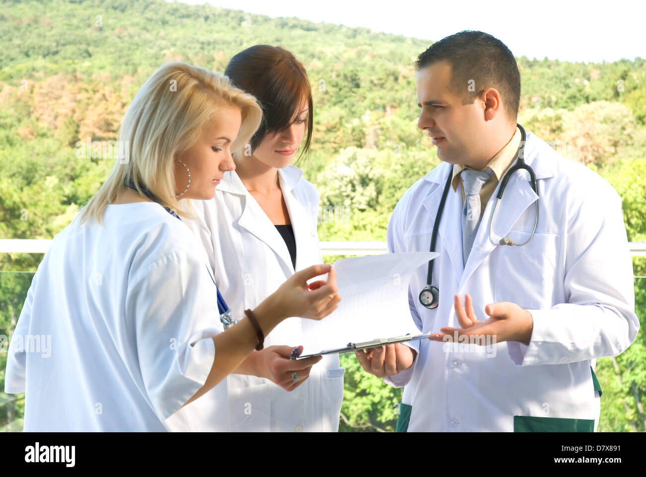 A doctor and nurses talking on the terrace Stock Photo