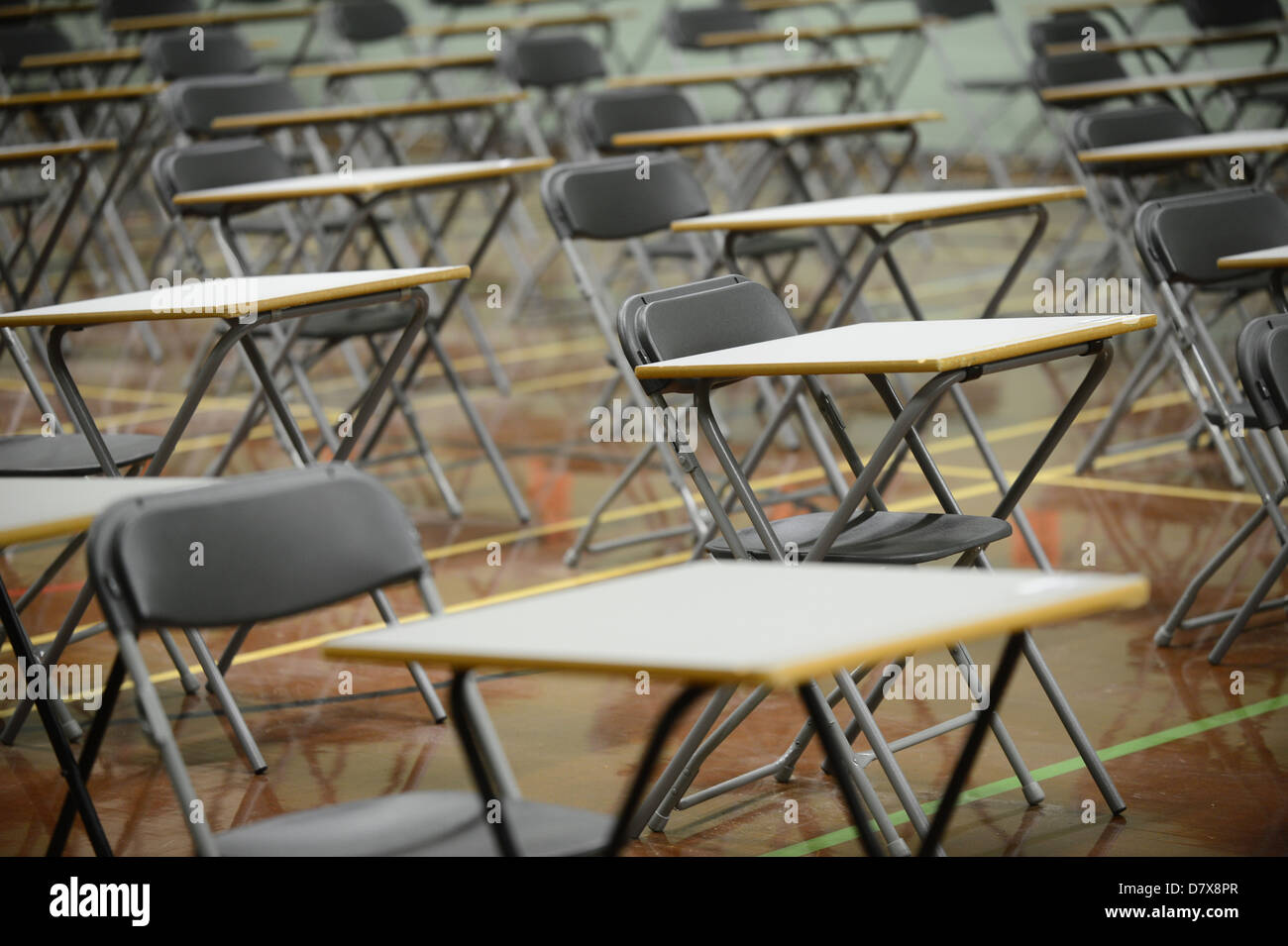 desks set out in a school hall in preparation for exam empty tables Stock Photo