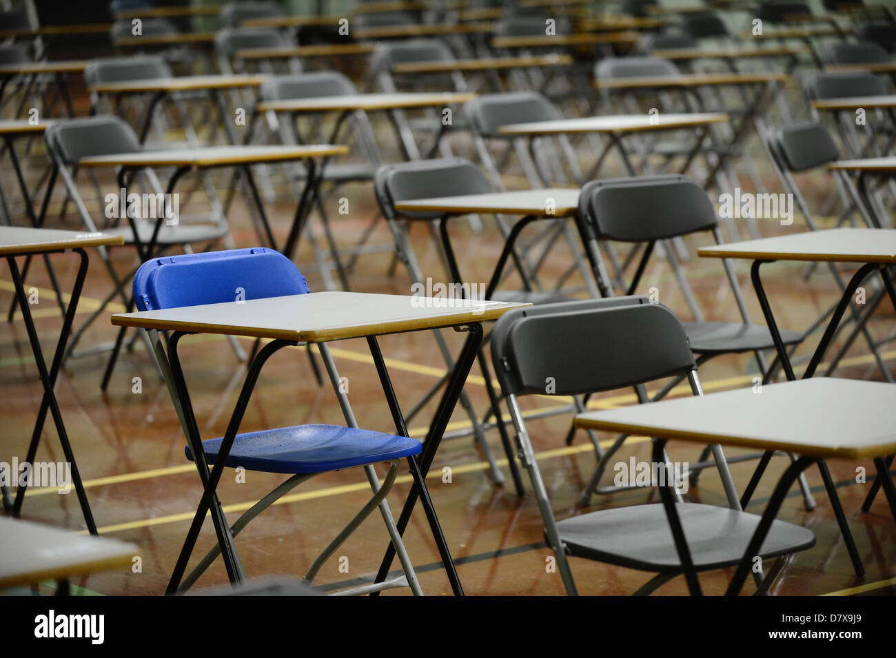 desks set out in a school hall in preparation for exam empty tables Stock Photo