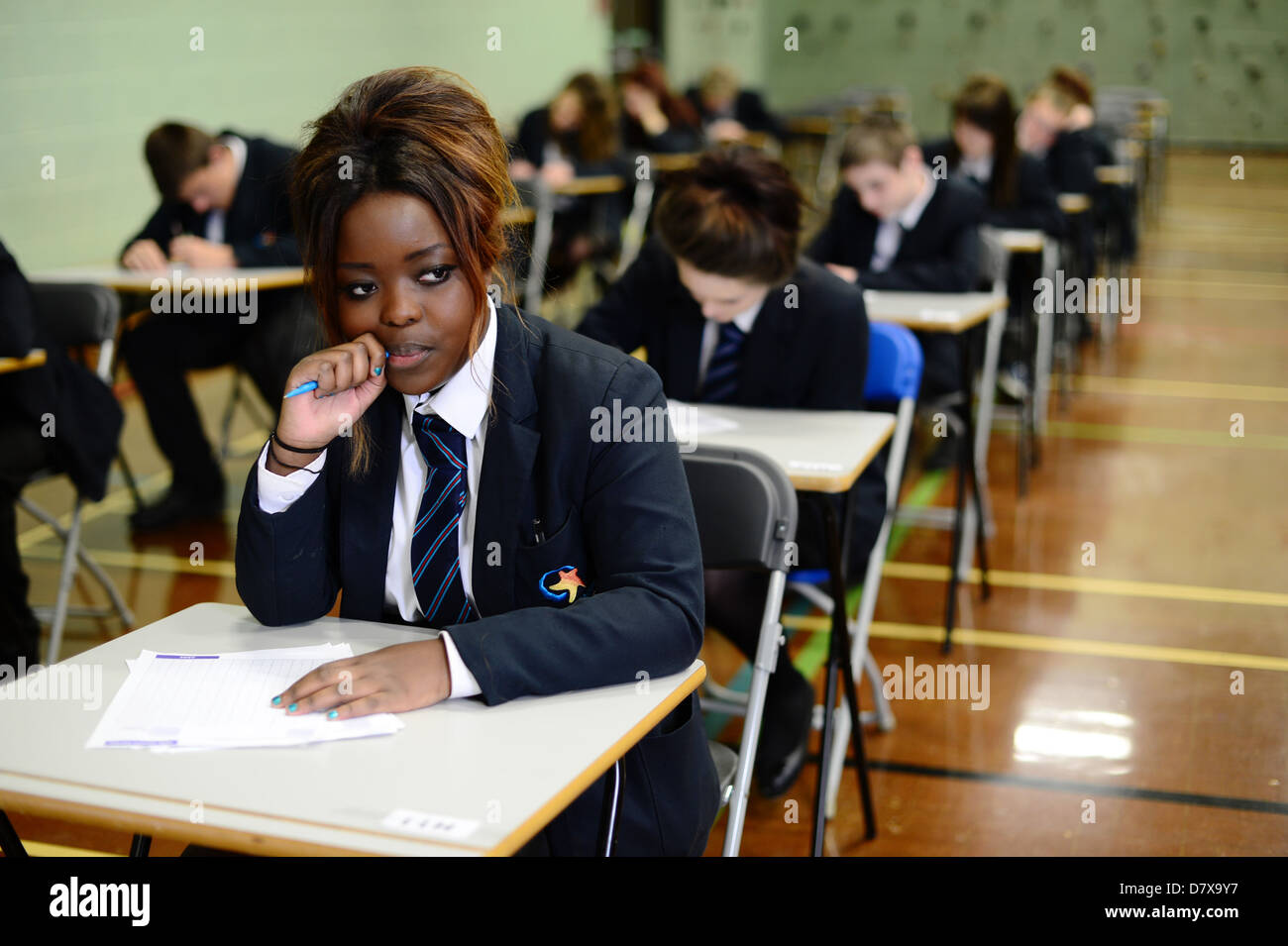 Secondary School pupils sitting in a hall in exam conditions Stock Photo
