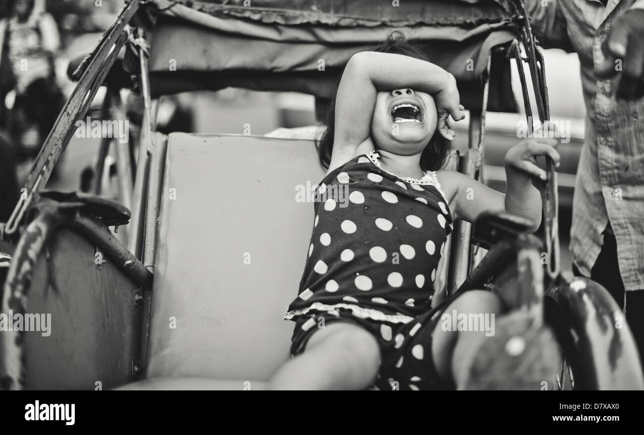 A young girl crying out loud on a cyclo, Cambodia Stock Photo