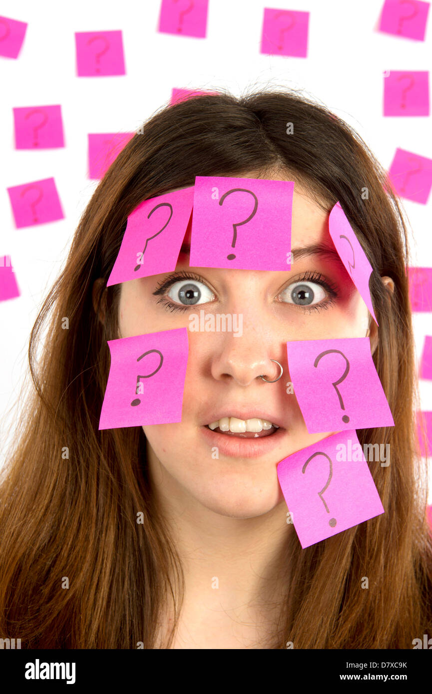Young woman with nose ring with pink sticky notes and question mark thinking about decision making Stock Photo