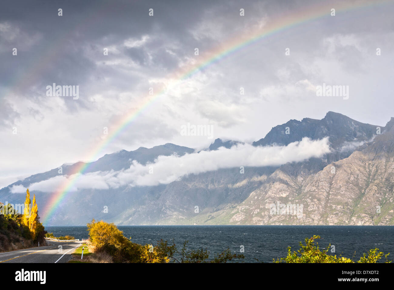 A rainbow over the Kingston Arm of Lake Wakatipu in New Zealand's South Island, seen in autumn. Stock Photo