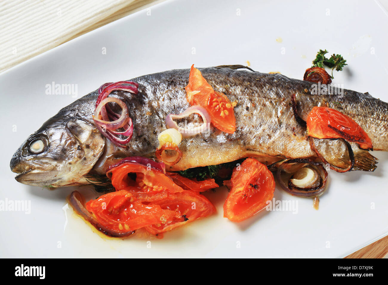 Herb-stuffed trout with tomatoes and onion Stock Photo