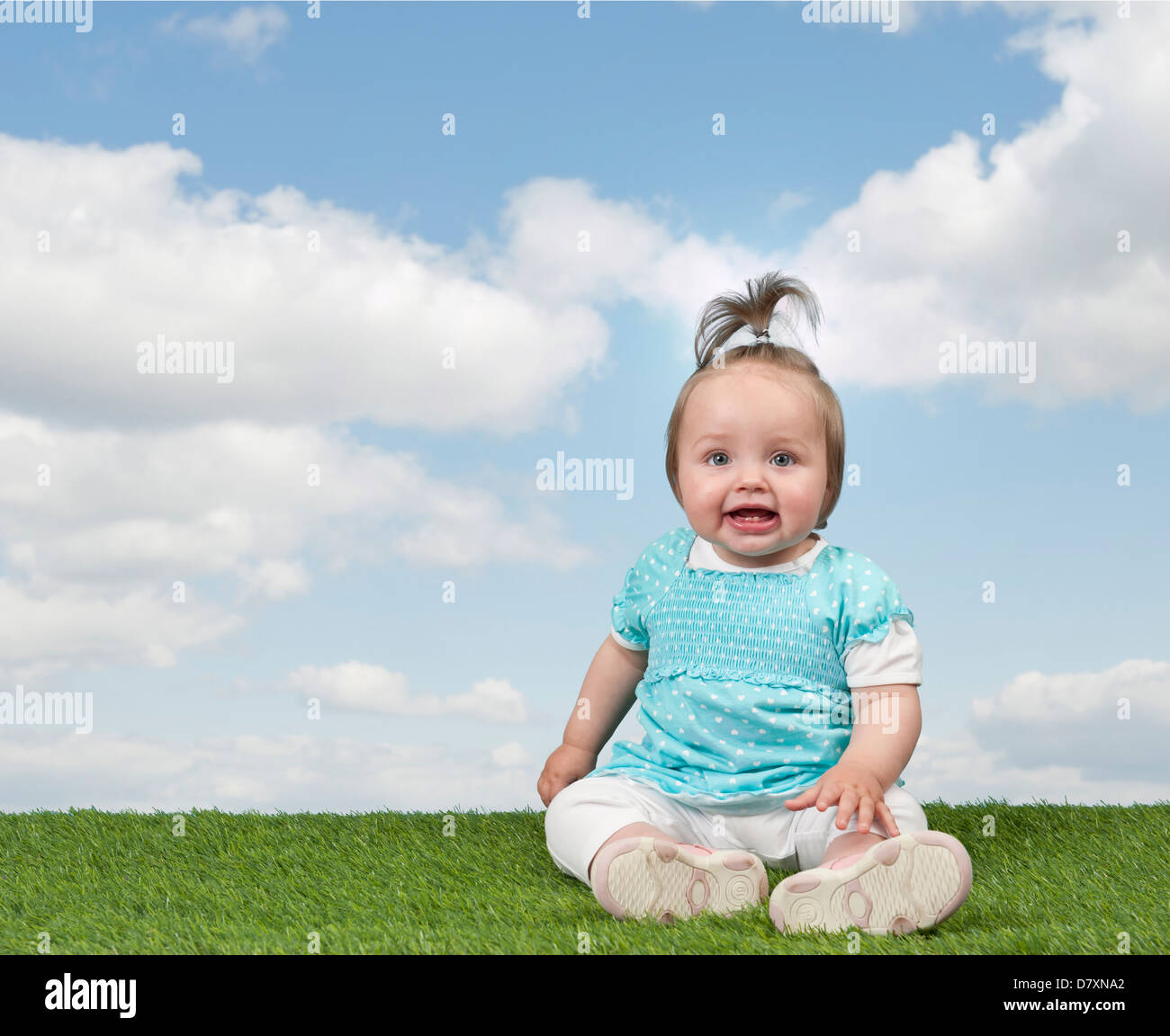 little baby girl seated on grass , blue sky with clouds Stock Photo - Alamy