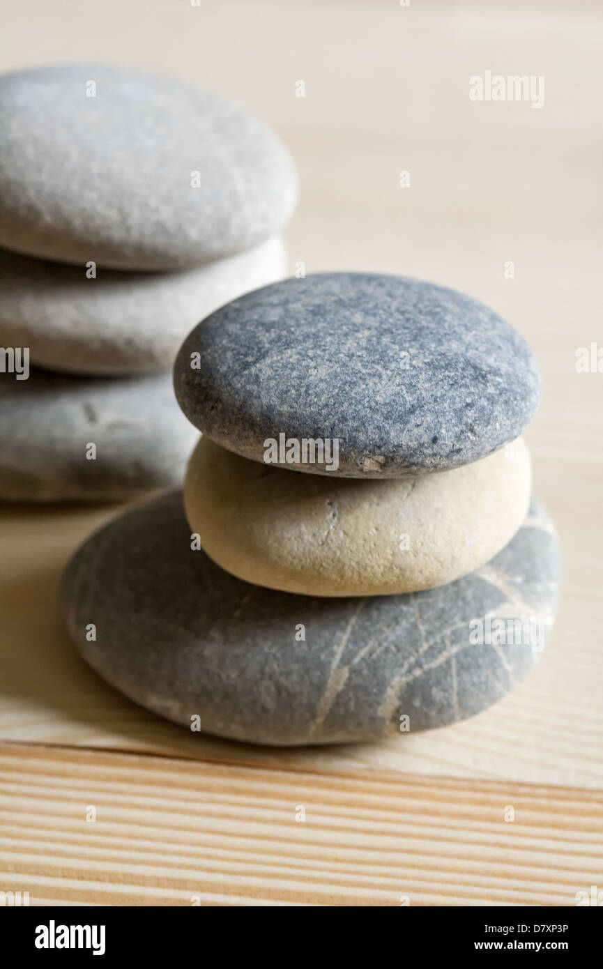 Six spa zen stones stacked on a light wood background Stock Photo