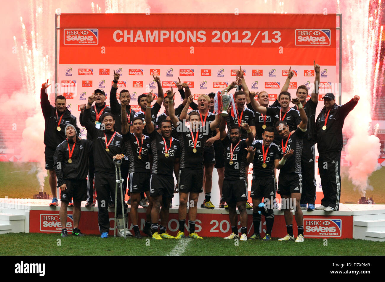 As fireworks go off behind them, the New Zealand All Blacks Sevens team celebrate their overall