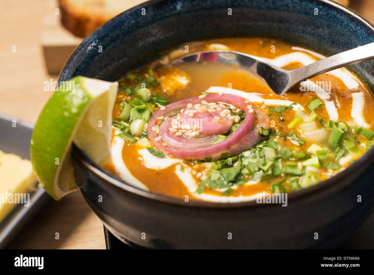 Zoomed bowl with soup and spoon in it Stock Photo