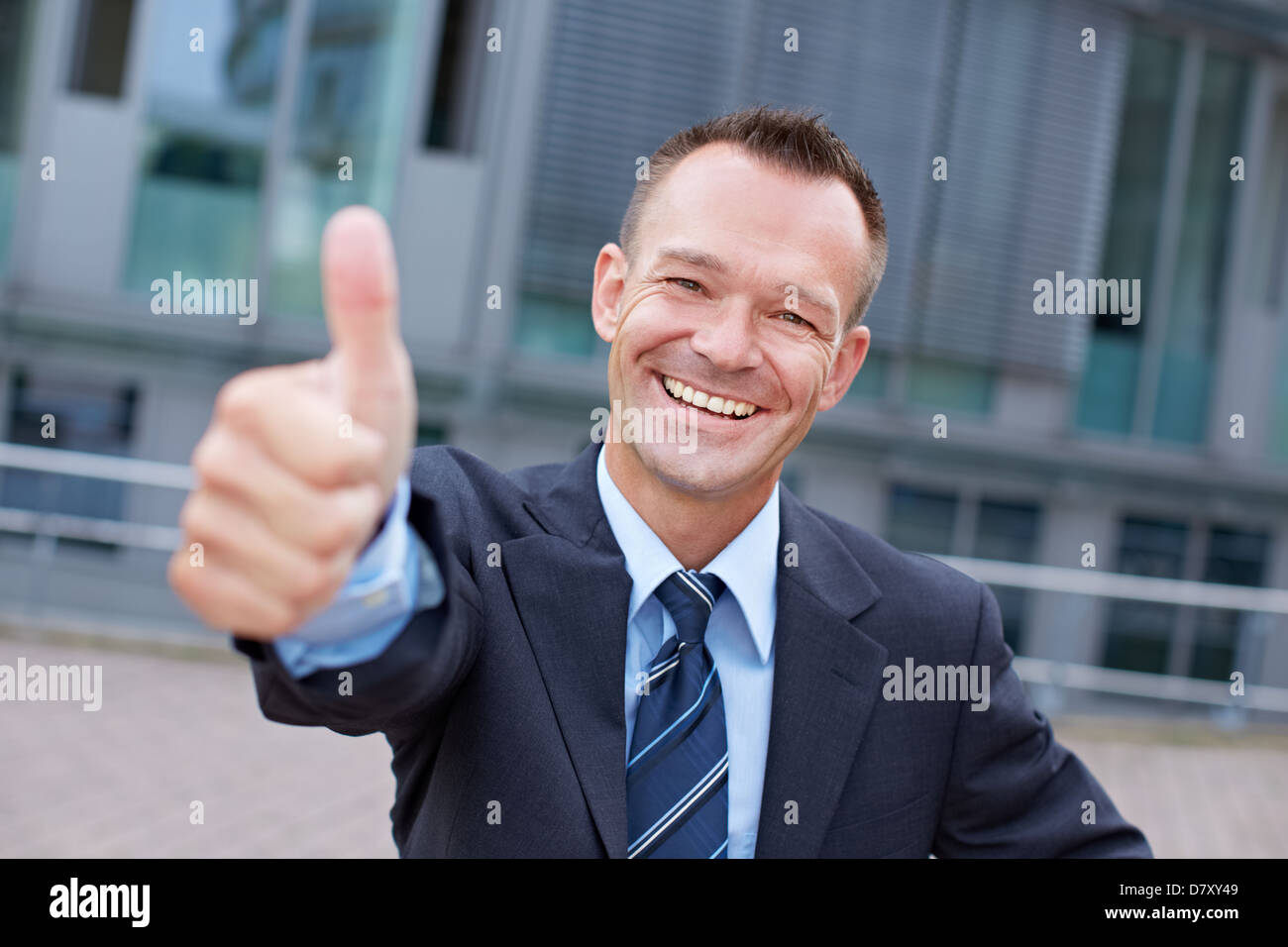 Sucessful smiling business manager holding his thumbs up Stock Photo