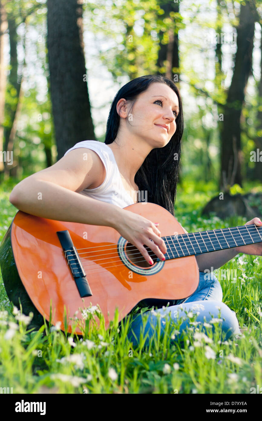 Young woman playing the guitar outdoors Stock Photo - Alamy