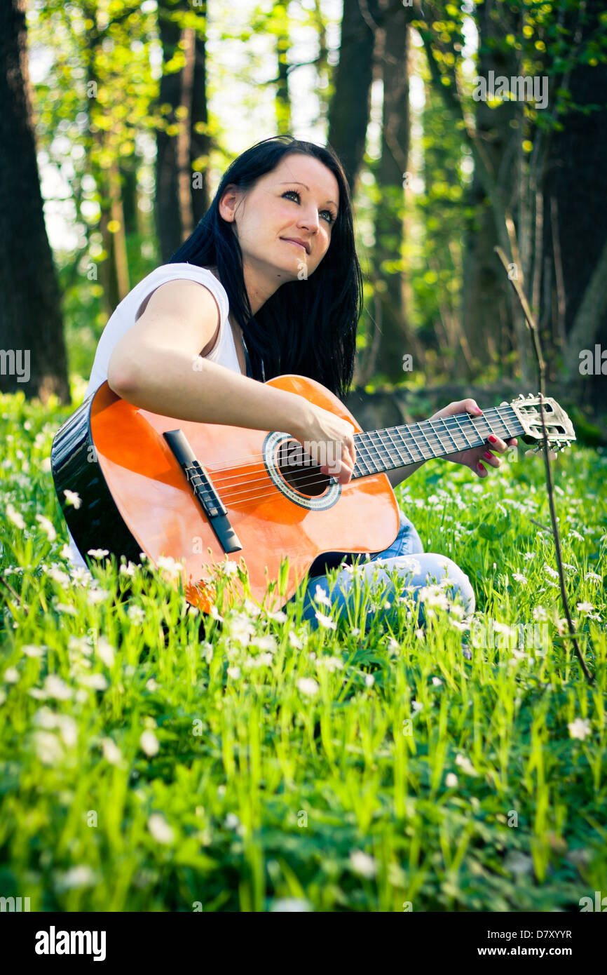 Young woman playing the guitar outdoors Stock Photo - Alamy