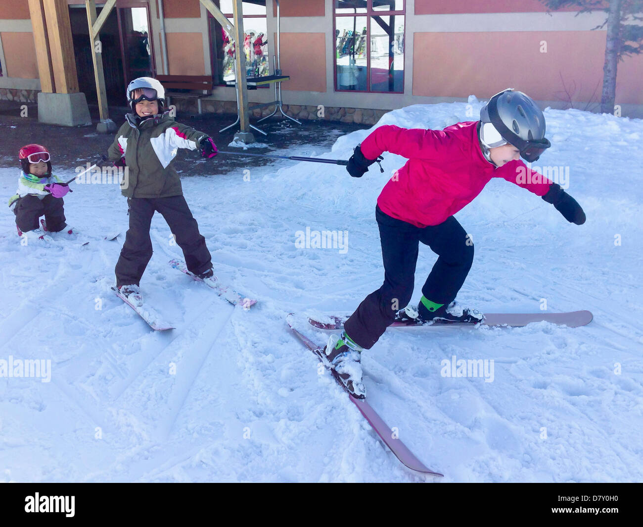 Children playing on skis in snowy yard - Smartphone Captured Stock Image