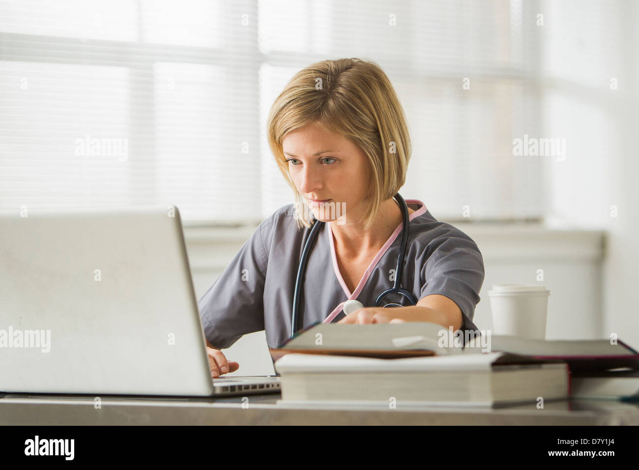 Caucasian nurse using laptop in doctor's office Stock Photo