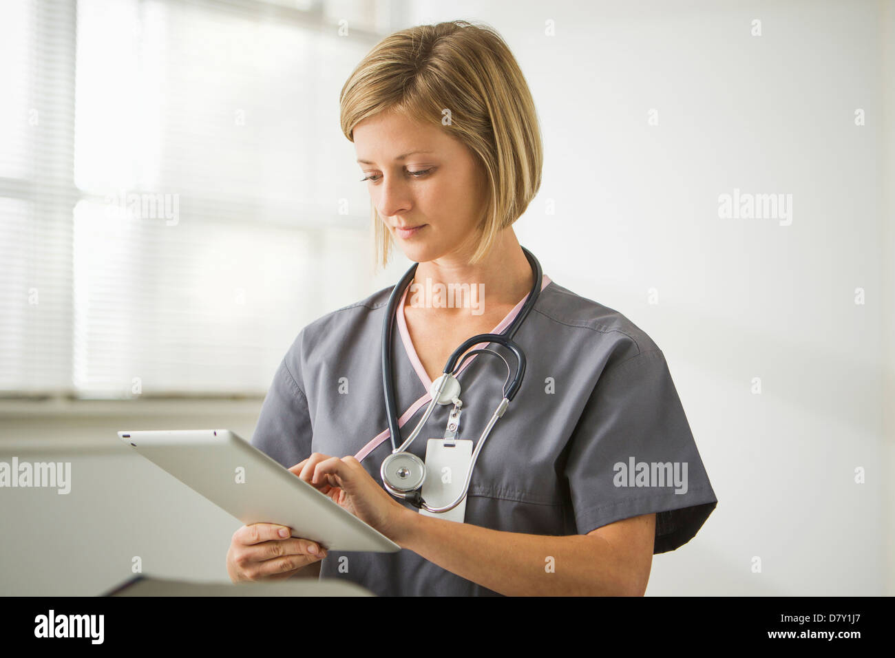 Caucasian nurse holding digital tablet Stock Photo - Alamy