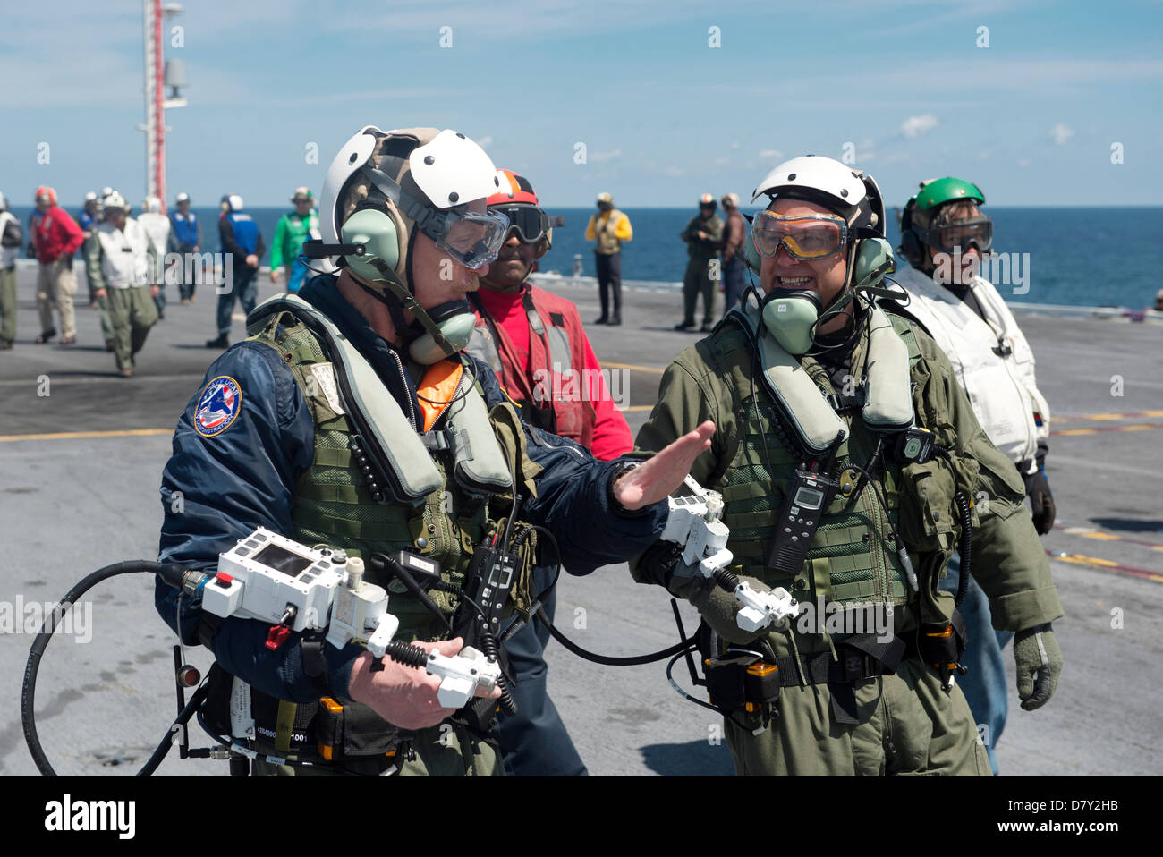 Dave Lorenz, left, and Bruce McFadden, deck operators for Northrop Grumman, discuss the launch of an X-47B  Unmanned Combat Air System aircraft prior to launch on the aircraft carrier USS George H.W. Bush May 14, 2013 in the Atlantic Ocean. The George H.W. Bush is the first aircraft carrier to successfully catapult launch an unmanned aircraft from its flight deck. Stock Photo