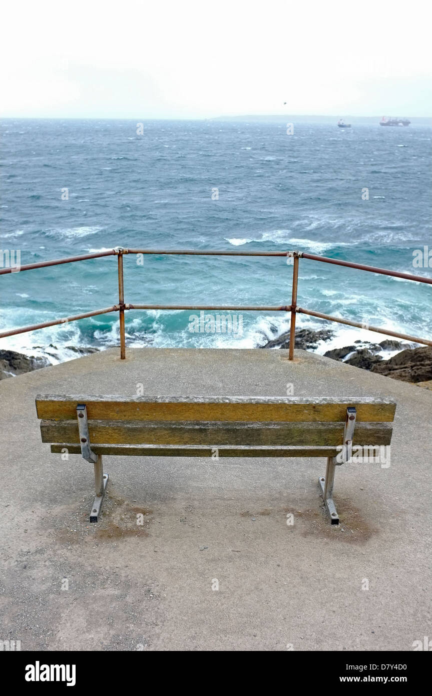 A bench overlooking a rough sea in Falmouth, Cornwall, UK. View from Pendennis Point Stock Photo