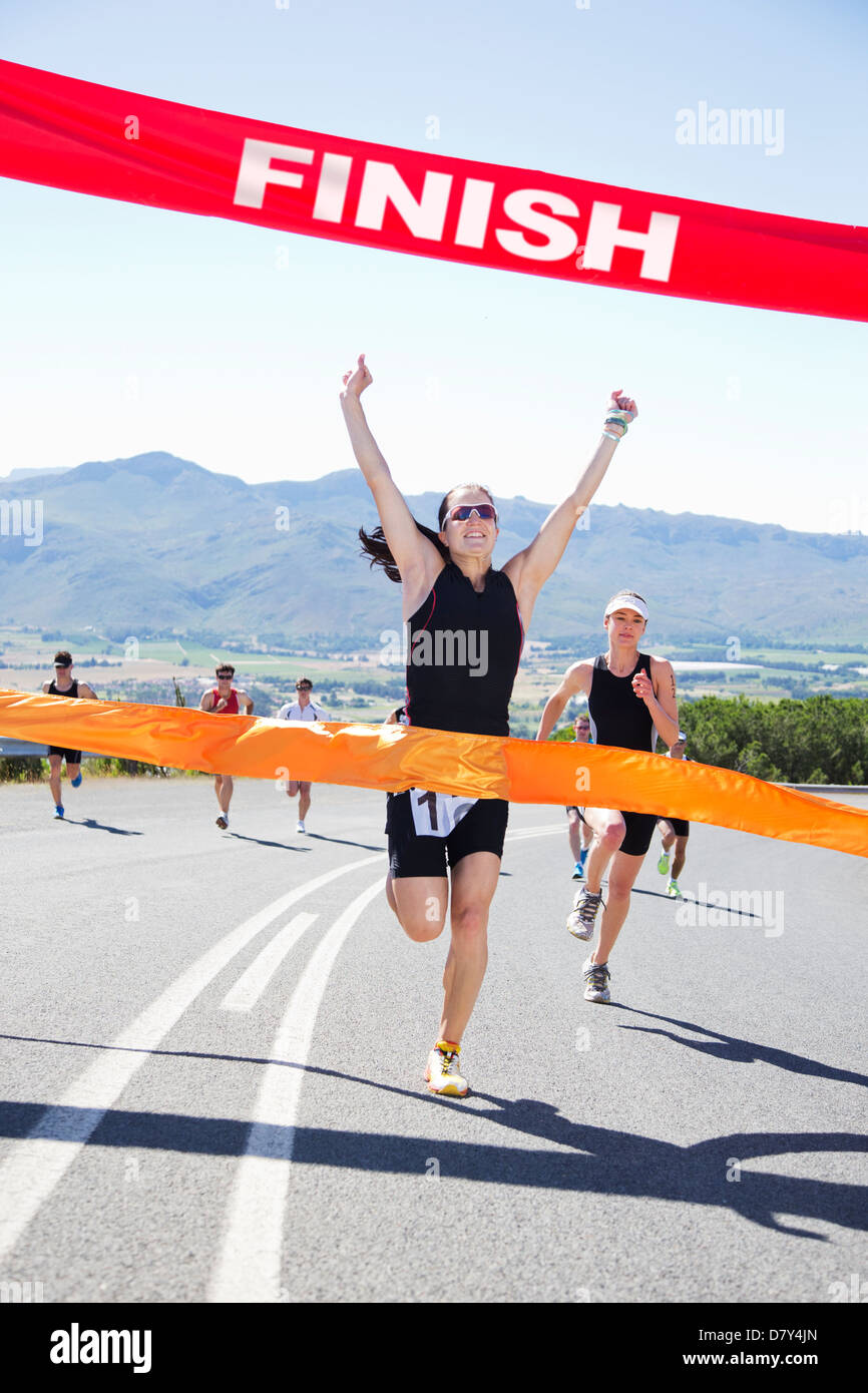 Runner crossing race finish line Stock Photo - Alamy