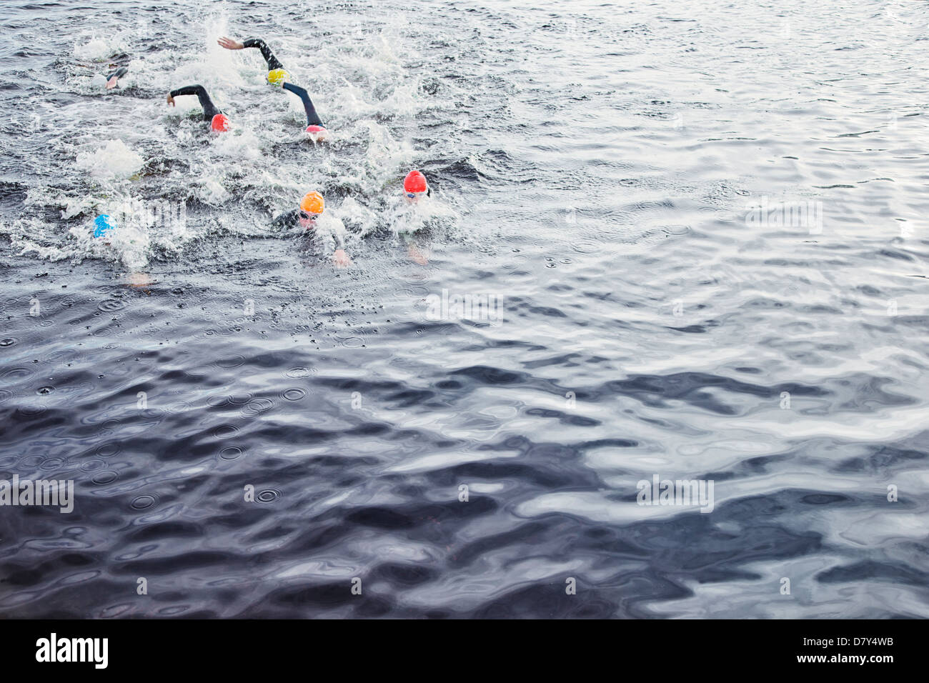 Triathletes splashing in water Stock Photo