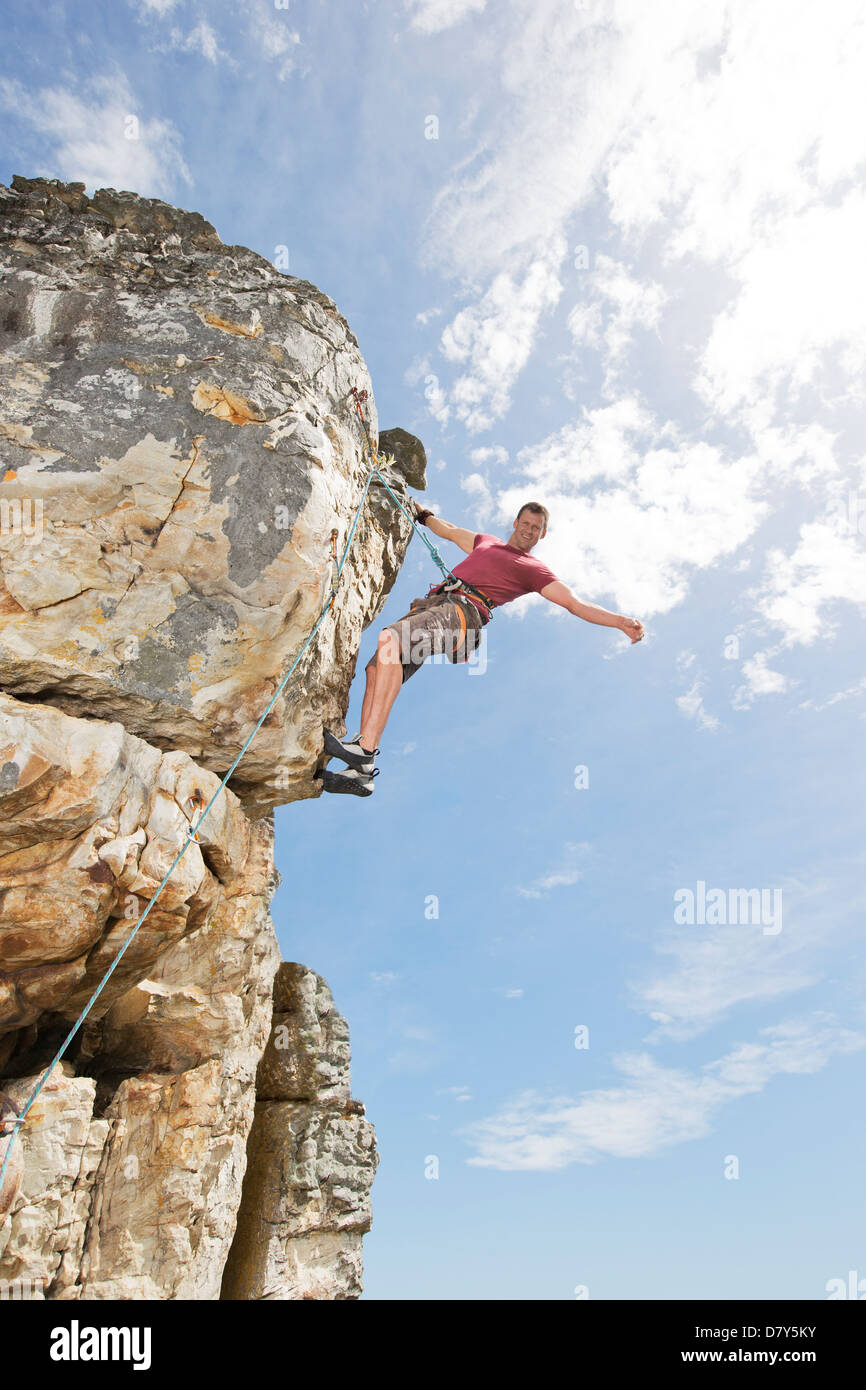 Climber scaling steep rock face Stock Photo