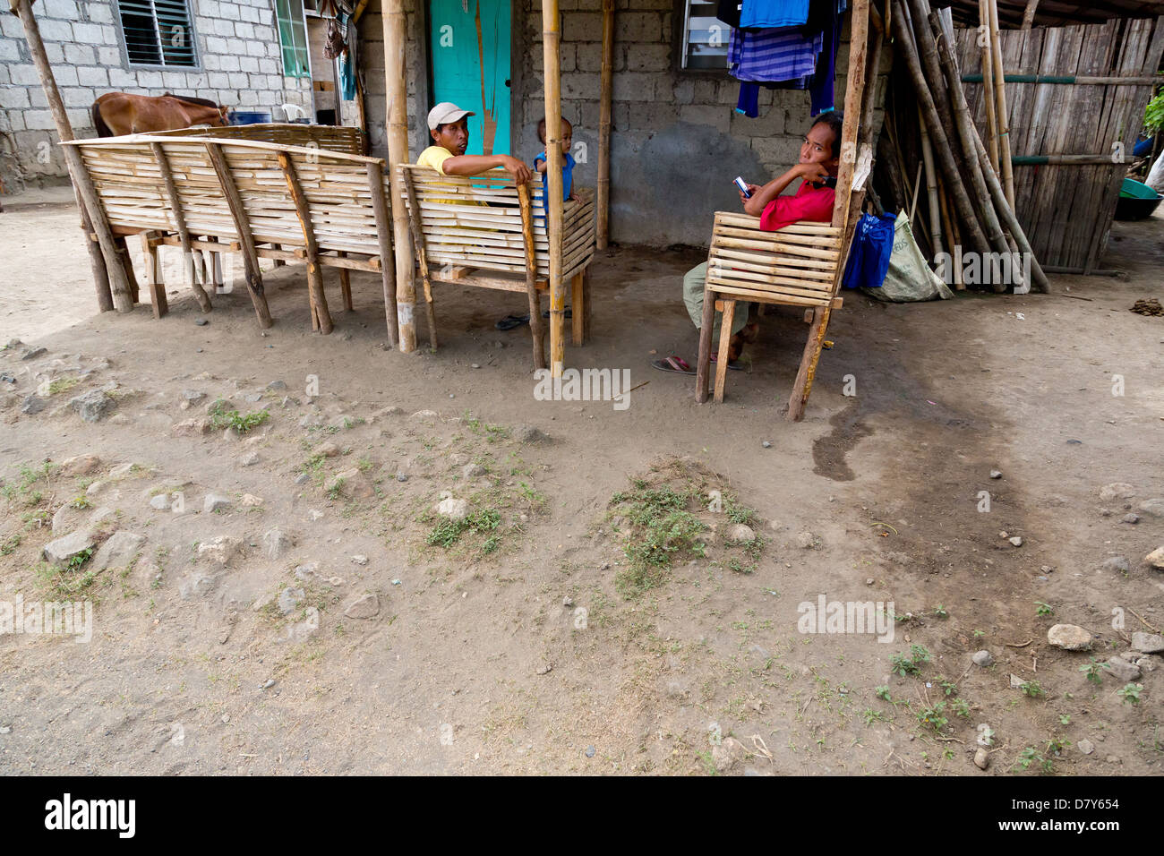 Men sitting in front of a House on the Taal Volcanic Island in the Philippines Stock Photo