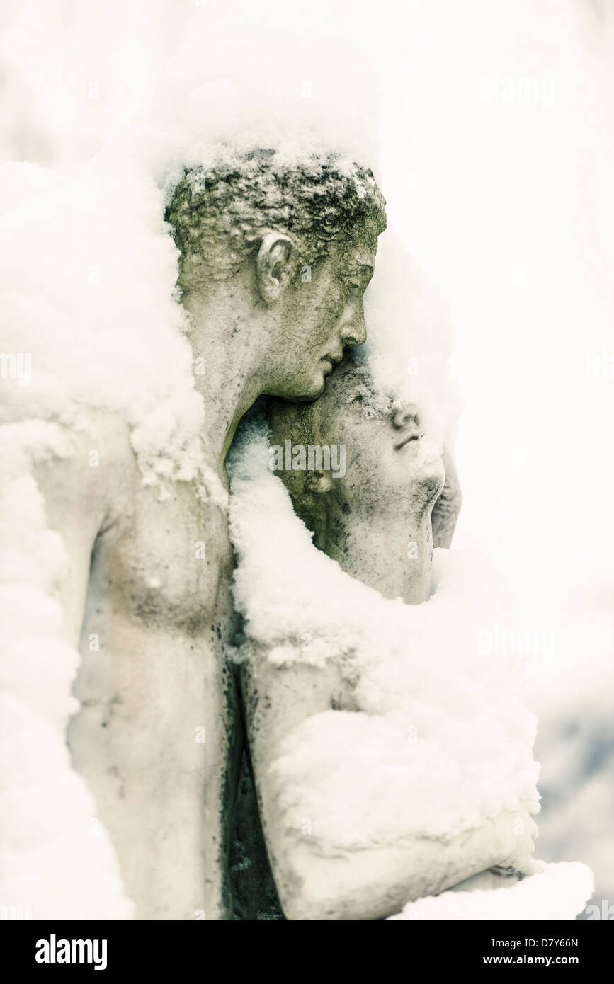 Statue of loving couple covered in snow and ice at winter Stock Photo