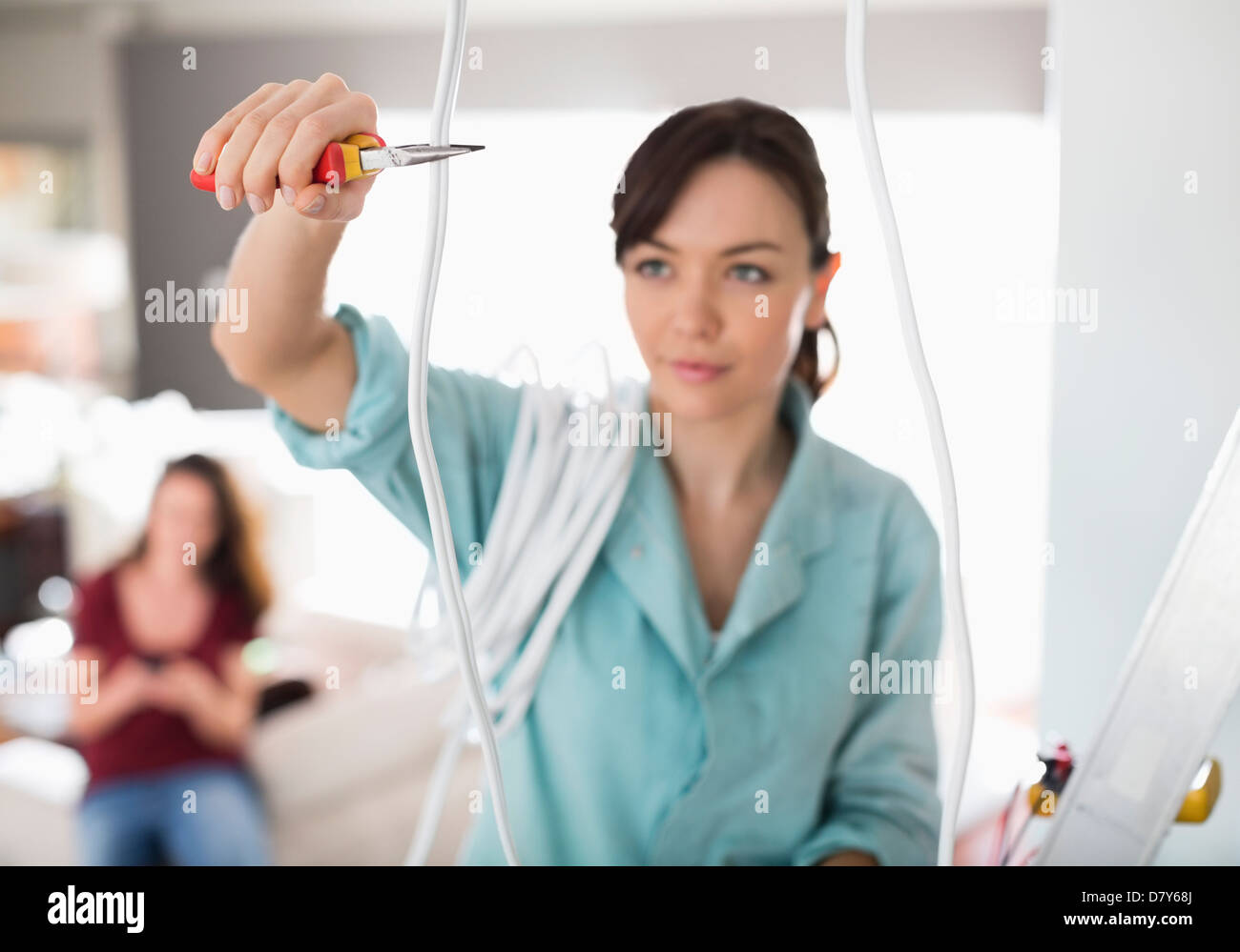 Female electrician cutting wires in home Stock Photo