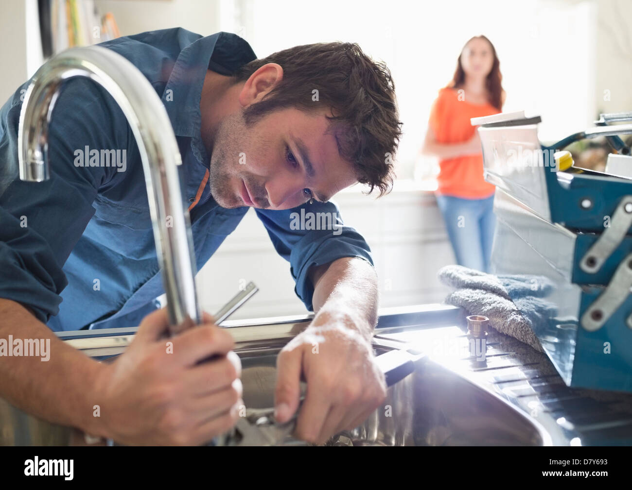 Plumber working on kitchen sink Stock Photo