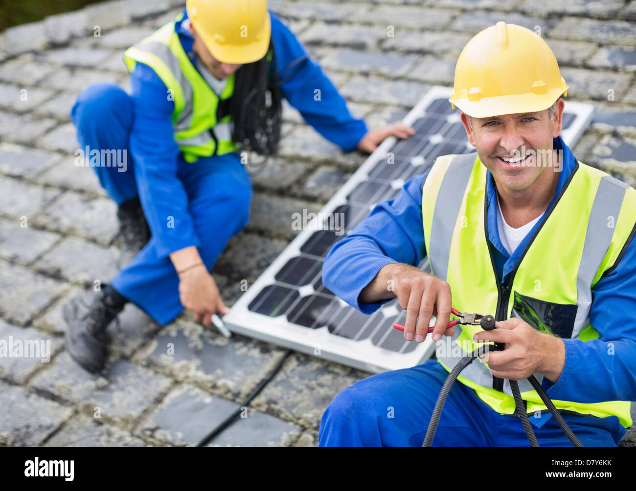 Workers installing solar panel on roof Stock Photo