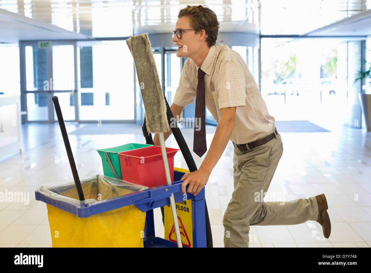 Businessman pushing cleaning cart in office Stock Photo Alamy