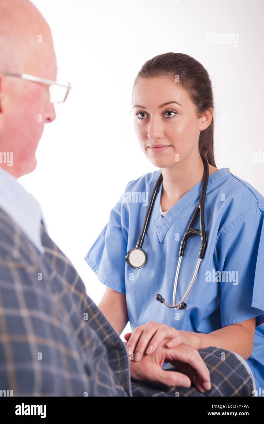 Elderly male patient being comforted by young female nurse/doctor. Stock Photo