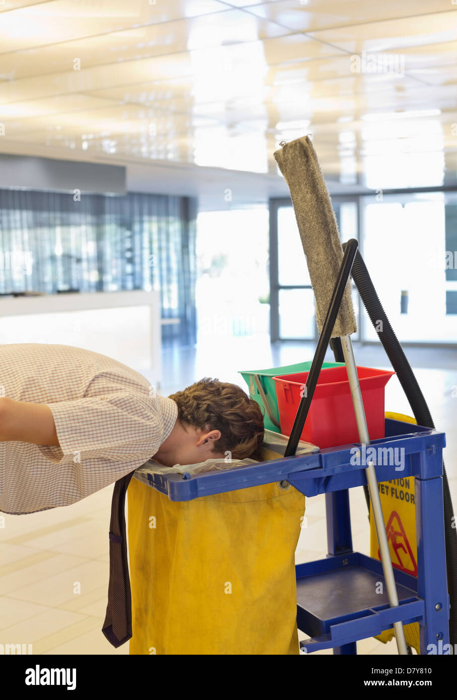 Businessman putting face in trash bag Stock Photo