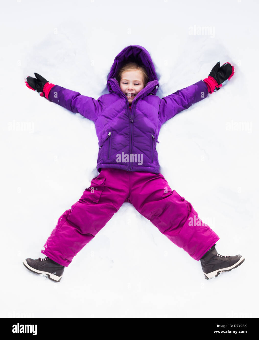 Caucasian girl making snow angel outdoors Stock Photo Alamy