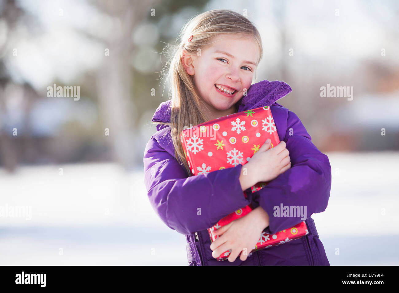 Caucasian girl holding Christmas present Stock Photo
