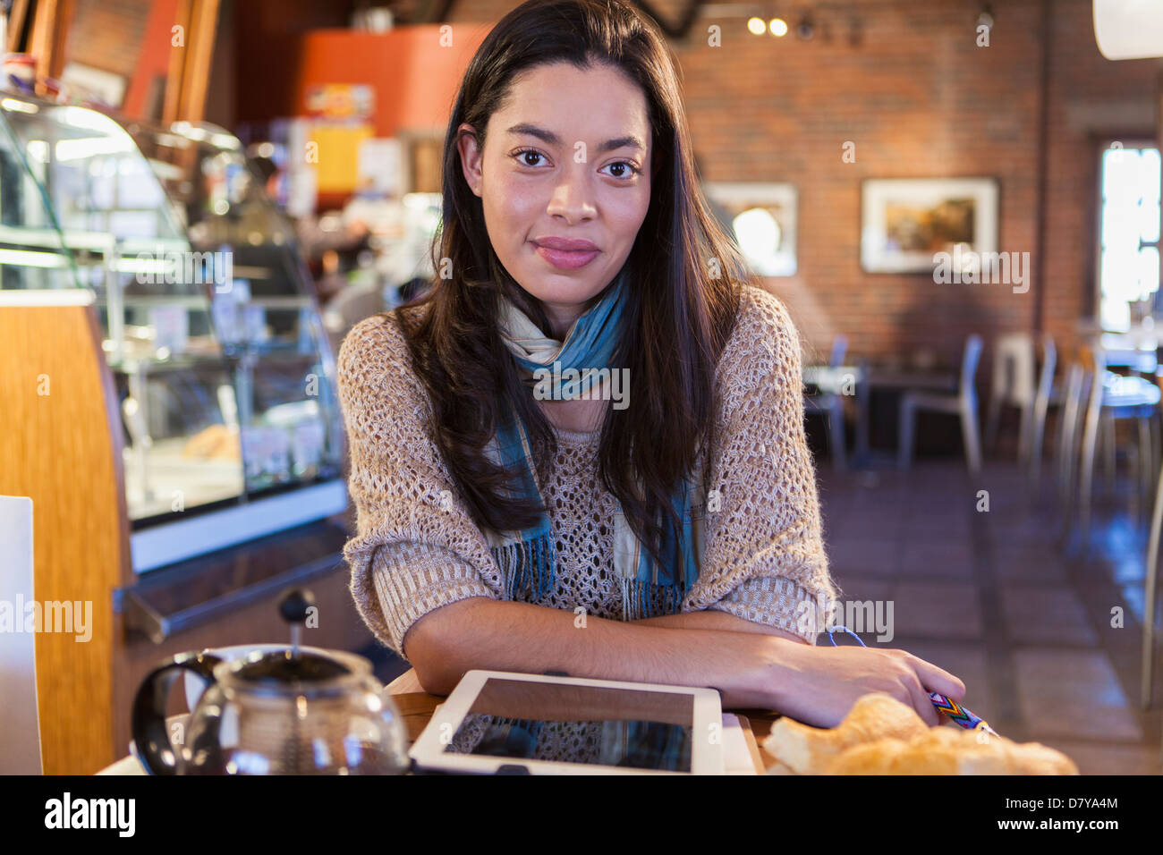 Mixed race woman using tablet computer in coffee shop Stock Photo