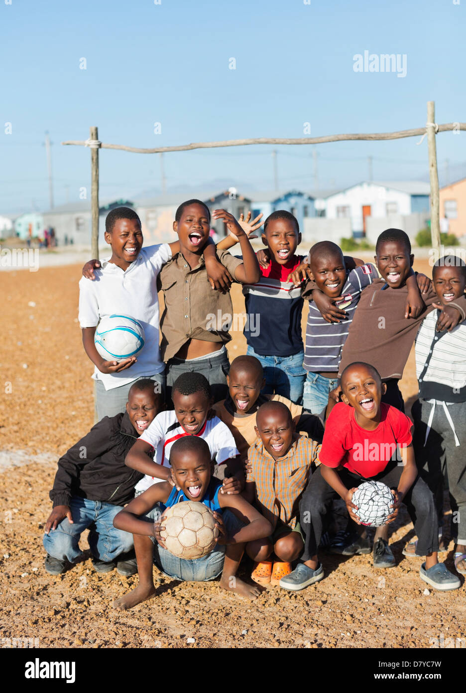 Boys holding soccer balls in dirt field Stock Photo Alamy