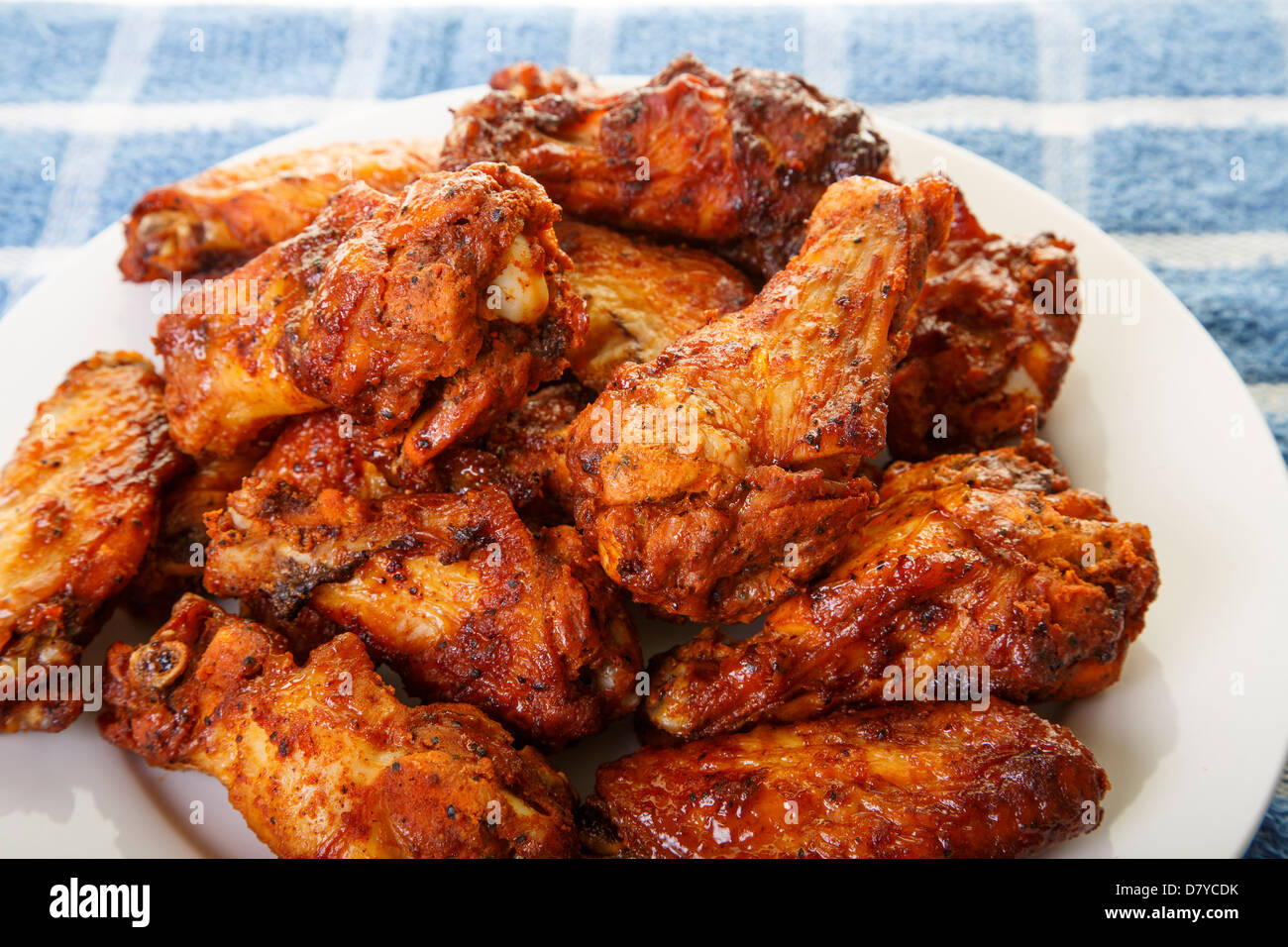 A white plate of spicy, mesquite flavored chicken wings Stock Photo
