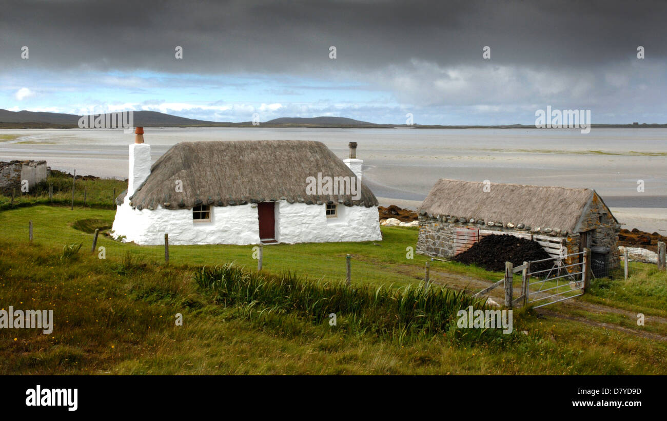 A traditional crofters cottage known as a blackhouse with thatched roof on the Isle of North Uist, Western Isles, Scotland. Stock Photo