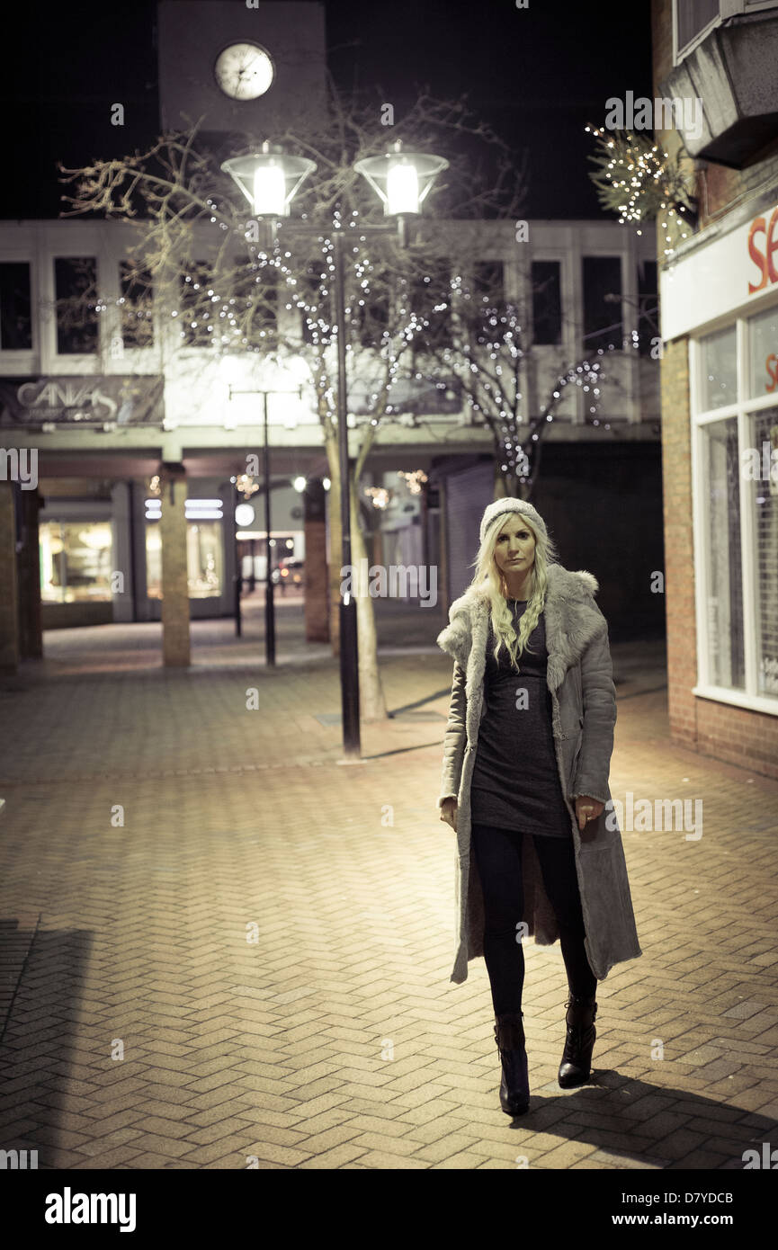 Woman alone on a city street at night. Stock Photo